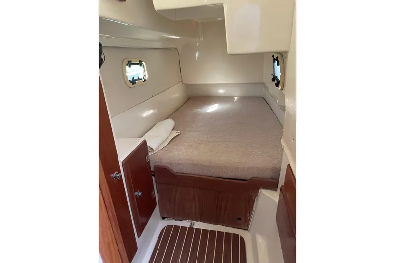 Slide: The Image of Cozy cabin interior of 2009 PCI 105 MC boat with bed and wooden accents. - 21