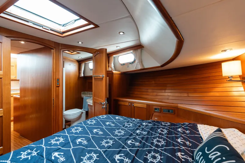 Slide: The Image of Luxurious 2011 Grand Banks 46 Eastbay SX yacht cabin with wood paneling and nautical bedding. - 13