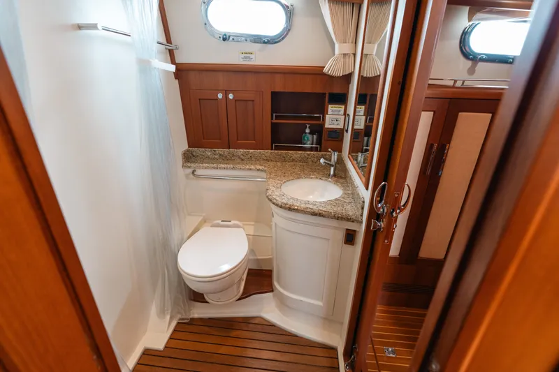 Slide: The Image of Luxurious bathroom in 2011 Grand Banks 46 Eastbay SX yacht with wood accents and granite countertop. - 15