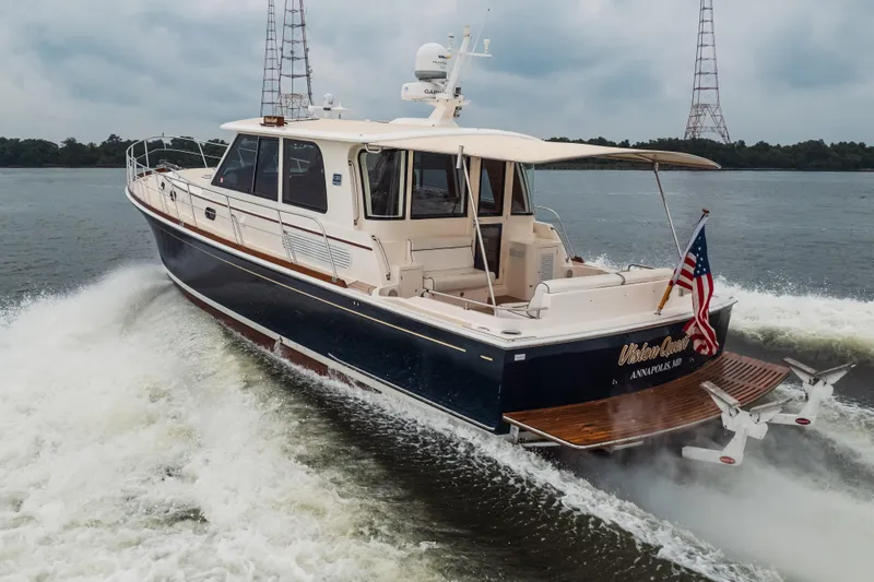 Slide: The Image of 2011 Grand Banks 46 Eastbay SX cruising on water, displaying American flag. - 2