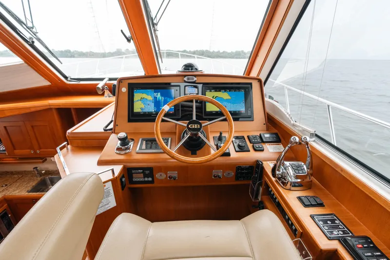 Slide: The Image of Helm of 2011 Grand Banks 46 Eastbay SX yacht with navigation screens and wooden steering wheel. - 5