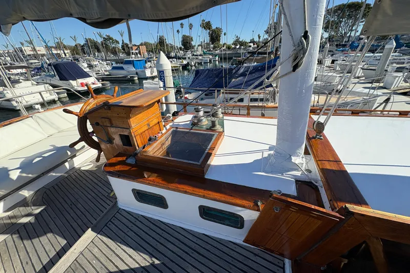 Slide: The Image of 1979 Formosa 51 sailboat deck with wooden helm, docked in a marina. - 13
