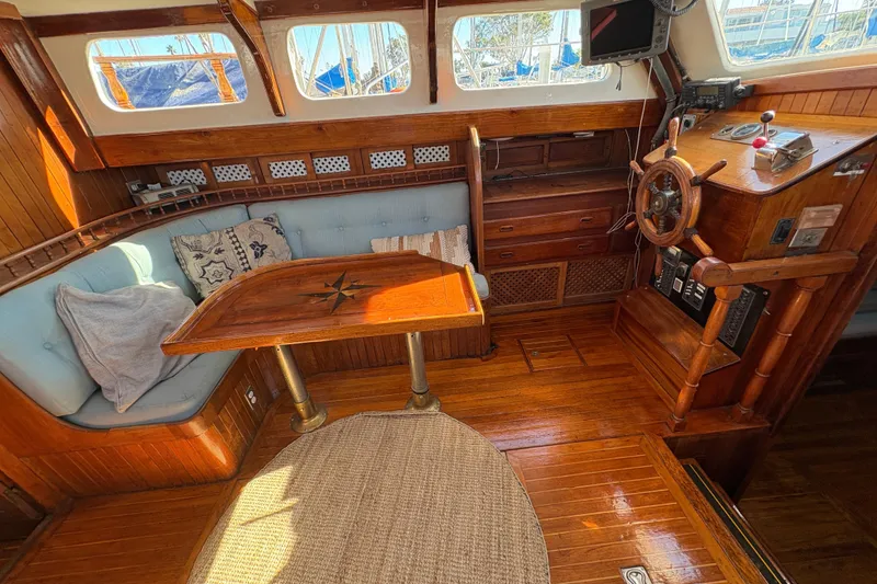 Slide: The Image of 1979 Formosa 51 yacht interior with wooden helm, seating, and nautical decor. - 21
