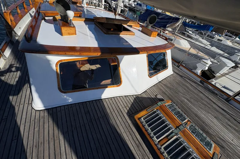 Slide: The Image of 1979 Formosa 51 yacht deck with wooden accents and windows, docked at a marina. - 39