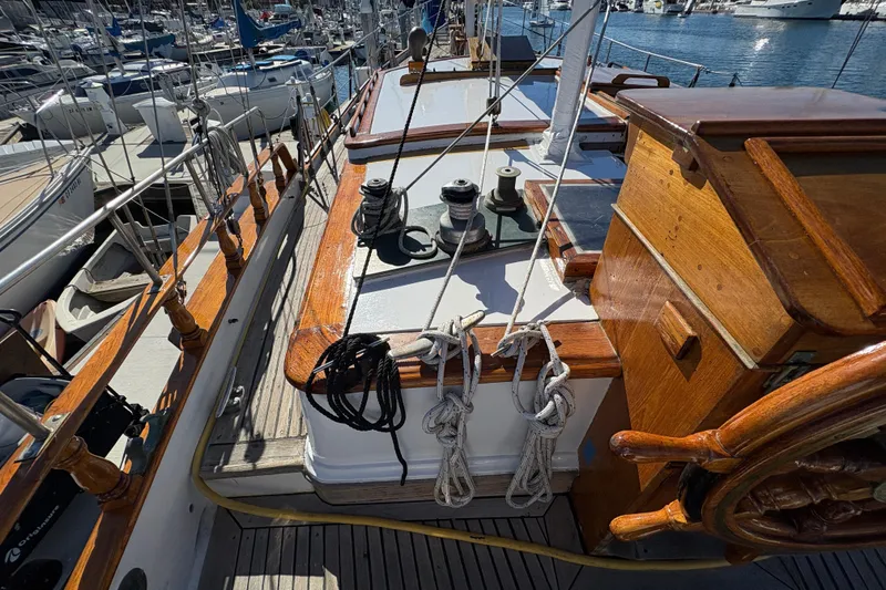 Slide: The Image of 1979 Formosa 51 sailboat deck with wooden details and marina background. - 5