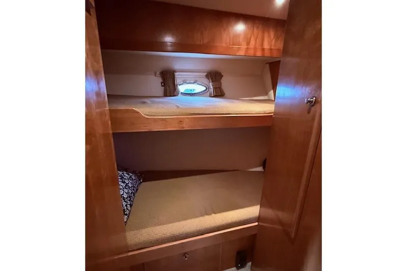 Slide: The Image of Bunk beds in 2007 Navigator 58 yacht cabin with wooden interior and porthole window. - 12