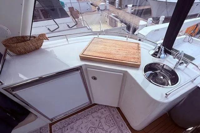 Slide: The Image of 2007 Navigator 58 yacht kitchen area with sink, cutting board, and storage. - 17