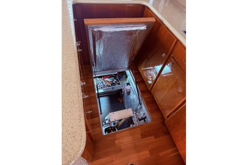 Slide: The Image of Engine compartment of a 2007 Navigator 58 yacht, featuring wooden cabinetry and open access panel. - 22