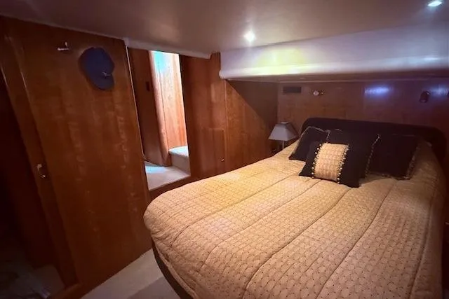 Slide: The Image of Luxurious bedroom interior of 2007 Navigator 58 yacht with cozy bedding and wooden paneling. - 8