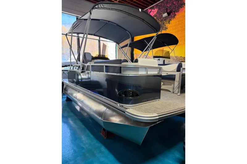 The Image of 2025 Avalon Venture Cruise Rear Bench pontoon boat with canopy in showroom. - 1