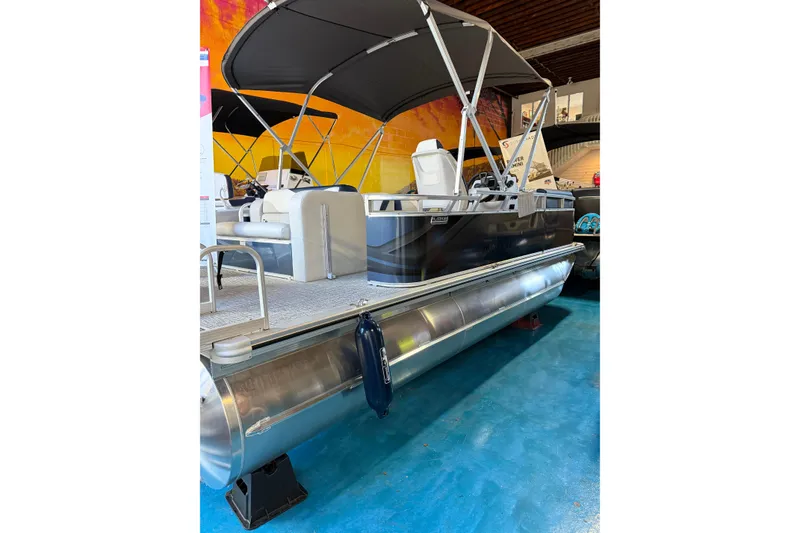 Slide: The Image of 2025 Avalon Venture Cruise Rear Bench pontoon boat with canopy on display indoors. - 10