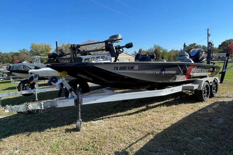 Slide: The Image of 2024 Xpress X21 Pro boat on trailer, parked outdoors on grass. - 2