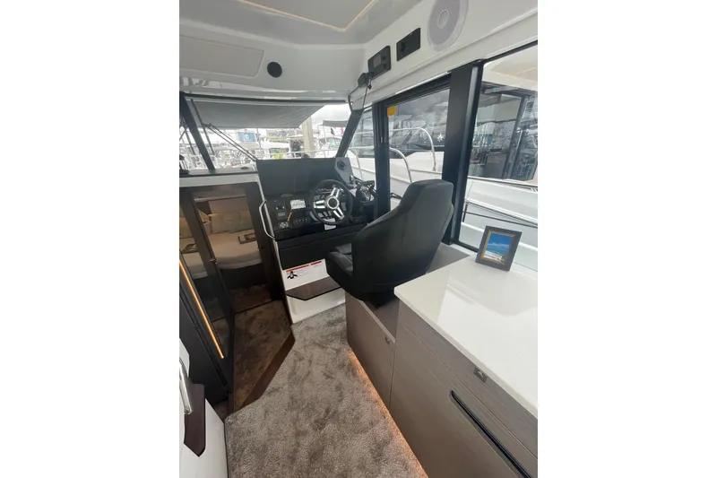 Slide: The Image of Interior of 2026 Jeanneau NC 1095 Fly Series 2 boat, featuring helm and seating area. - 11