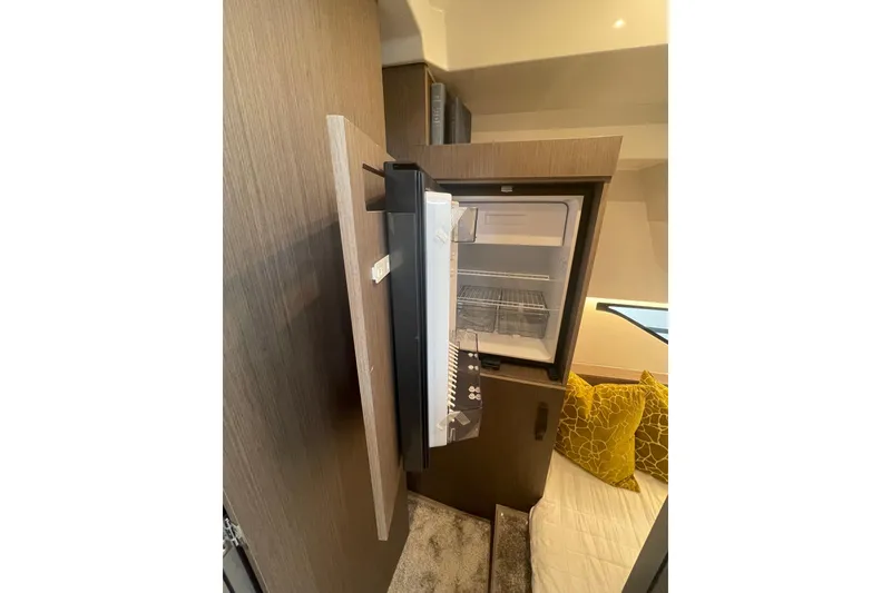 Slide: The Image of Open fridge in Jeanneau NC 1095 Fly Series 2, 2026 model, with cozy interior design. - 18