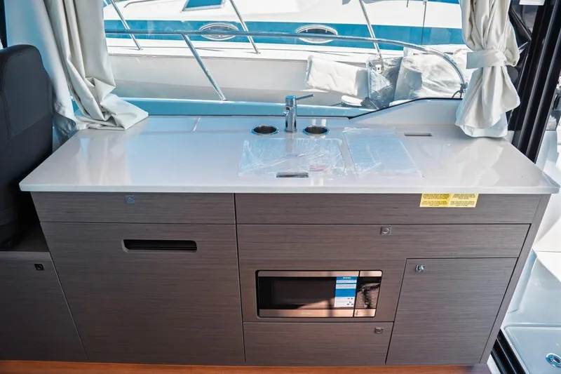 Slide: The Image of 2026 Jeanneau NC 1095 Fly Series 2 boat docked under cloudy skies. - 51