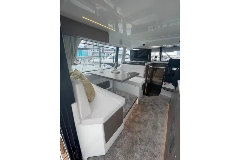 Slide: The Image of Interior of 2026 Jeanneau NC 1095 Fly Series 2 yacht, featuring modern seating and navigation area. - 7