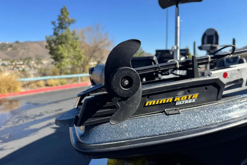 Slide: The Image of 2018 Triton 19 TrX Patriot with Minn Kota Ultrex trolling motor in a scenic outdoor setting. - 10