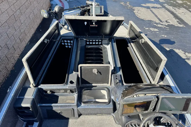Slide: The Image of 2018 Triton 19 TrX Patriot boat with open storage compartments and navigation equipment. - 15