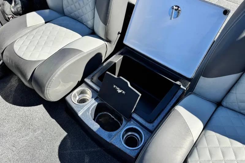 Slide: The Image of 2018 Triton 19 TrX Patriot boat interior with storage compartment and cup holders. - 17