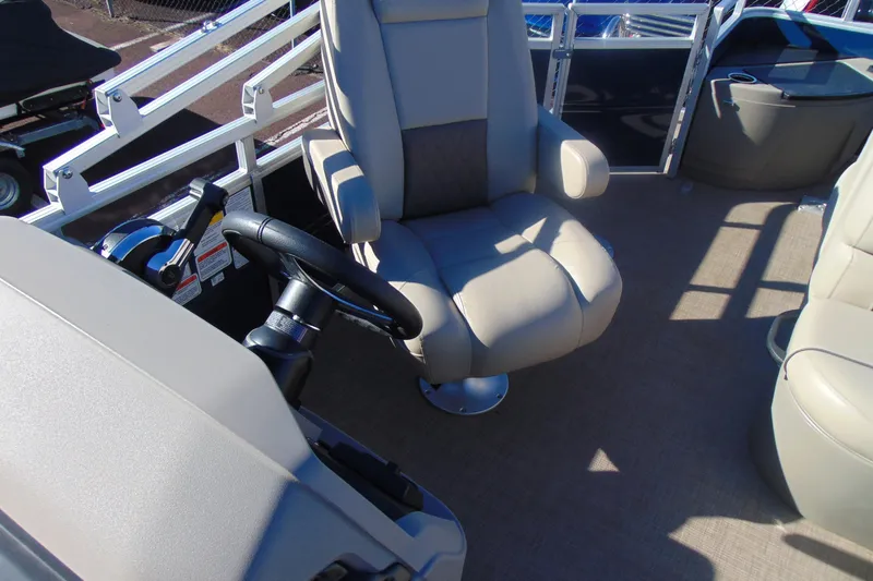 Slide: The Image of 2024 Sun Tracker Fishin' Barge 20 DLX interior with steering wheel and captain's chair. - 11