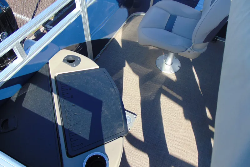 Slide: The Image of 2024 Sun Tracker Fishin' Barge 20 DLX interior with fishing seat and measuring board. - 13