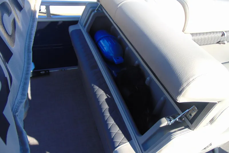 Slide: The Image of 2024 Sun Tracker Fishin' Barge 20 DLX storage compartment with seating and safety equipment. - 15