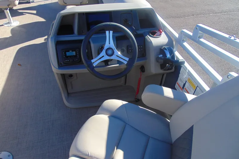 Slide: The Image of 2024 Sun Tracker Fishin' Barge 20 DLX helm with steering wheel and controls. - 17