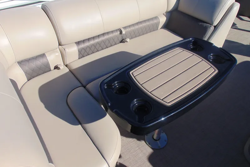Slide: The Image of 2024 Sun Tracker Fishin' Barge 20 DLX interior with beige seating and table. - 19