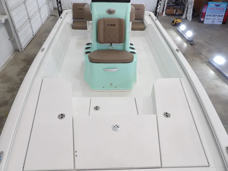 Slide: The Image of 2026 Avid 21FST boat interior with mint green console and tan seating in a garage setting. - 14