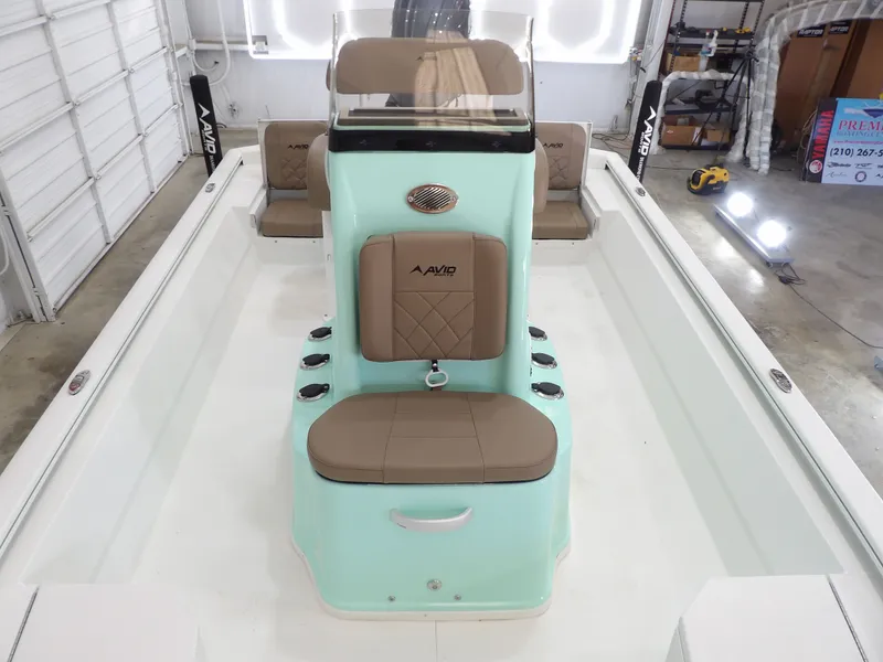 Slide: The Image of 2026 Avid 21FST boat interior with mint green console and tan seating in a garage. - 15