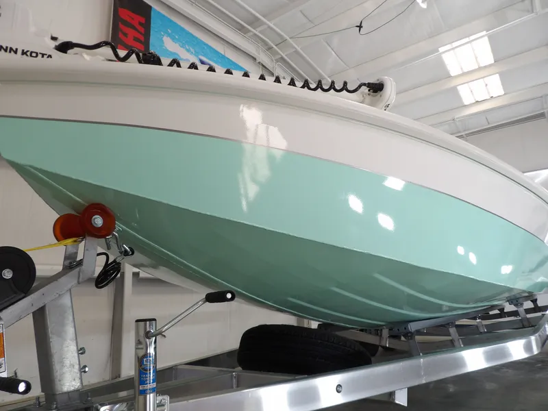 Slide: The Image of 2026 Avid 21FST boat on trailer, mint green hull, indoor showroom. - 5