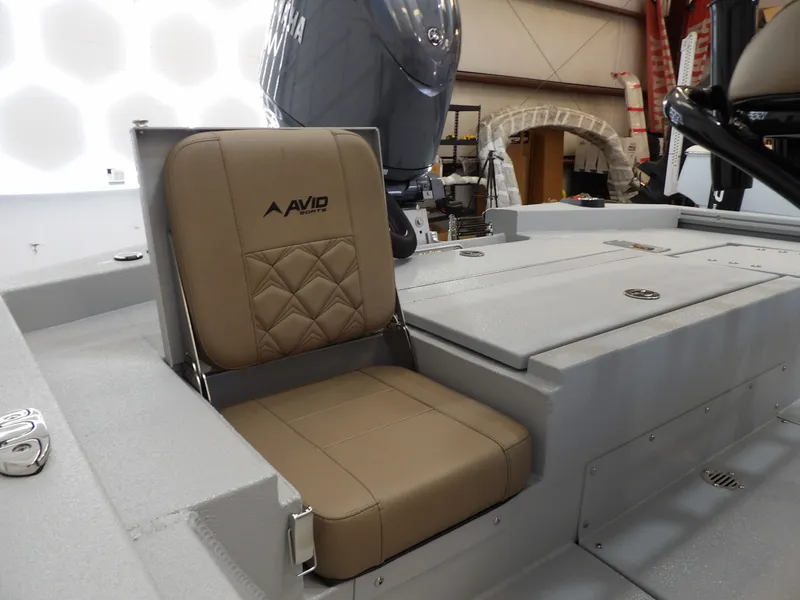 Slide: The Image of Avid 21FST 2026 boat seat with tan upholstery in a showroom setting. - 23