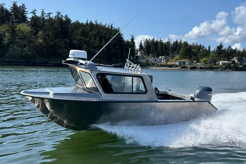 The Image of 2026 Northshore 24 boat cruising on a scenic lake with forested shoreline. - 0