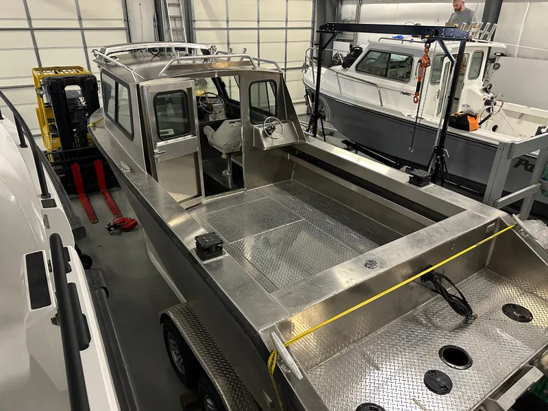 Slide: The Image of 2025 Northshore 24 boat in a showroom, featuring a sleek aluminum design and spacious deck. - 13