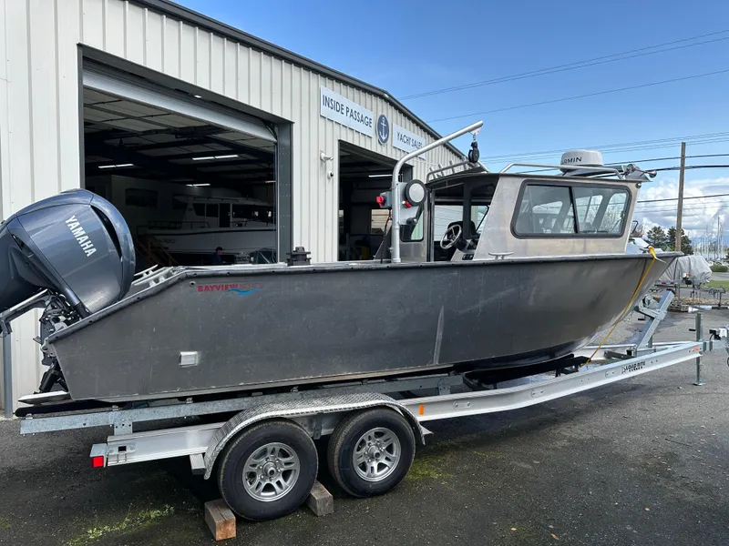 Slide: The Image of 2025 Northshore 24 boat on trailer outside a workshop, featuring a Yamaha outboard motor. - 15