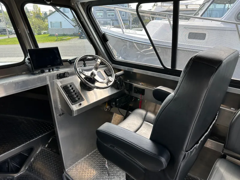 Slide: The Image of Interior of 2025 Northshore 24 boat with steering wheel and captain's chair. - 19