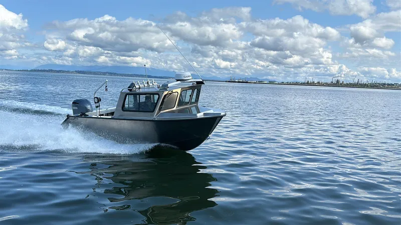 Slide: The Image of 2025 Northshore 24 boat cruising on a calm sea under a partly cloudy sky. - 2