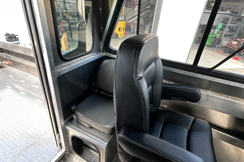 Slide: The Image of Interior of 2025 Northshore 24 boat with black leather seating and metal flooring. - 24