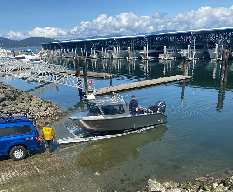 Slide: The Image of 2025 Northshore 24 boat being launched at a marina with clear skies and calm waters. - 3