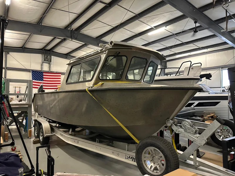 Slide: The Image of 2025 Northshore 24 boat on trailer in warehouse with American flag. - 4