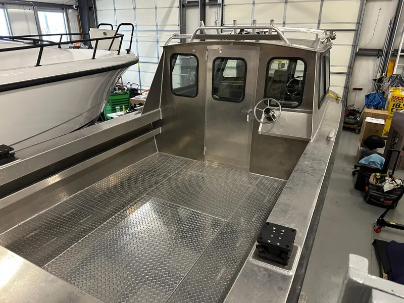 Slide: The Image of 2025 Northshore 24 boat with aluminum deck in a storage facility. - 8