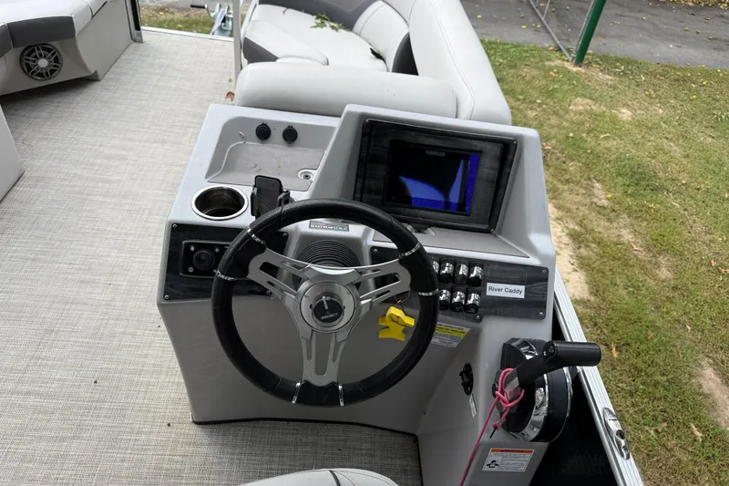 Slide: The Image of 2021 Harris Cruiser 210 boat dashboard with steering wheel and control panel. - 11
