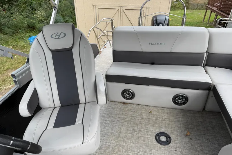 Slide: The Image of 2021 Harris Cruiser 210 boat interior with gray seating and speakers. - 12