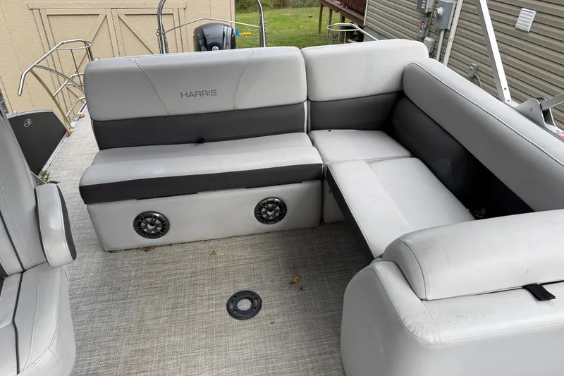 Slide: The Image of 2021 Harris Cruiser 210 boat interior with gray seating and built-in speakers. - 13