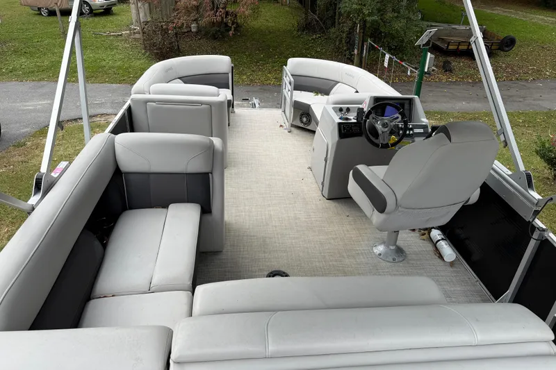 Slide: The Image of 2021 Harris Cruiser 210 pontoon boat interior with spacious seating and helm. - 7