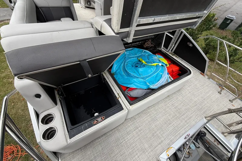 Slide: The Image of 2021 Harris Cruiser 210 boat storage compartments with water sports gear and seating. - 8