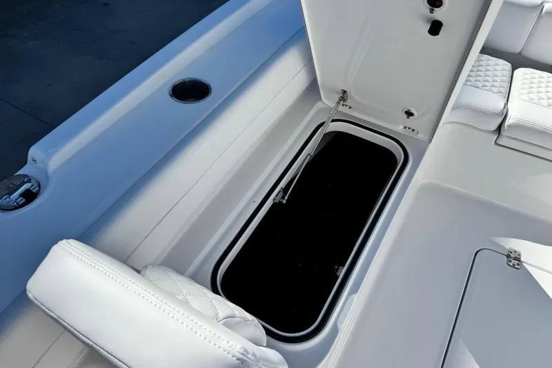 Slide: The Image of 2026 Caymas 28 HB boat interior with open storage compartment and cushioned seating. - 15