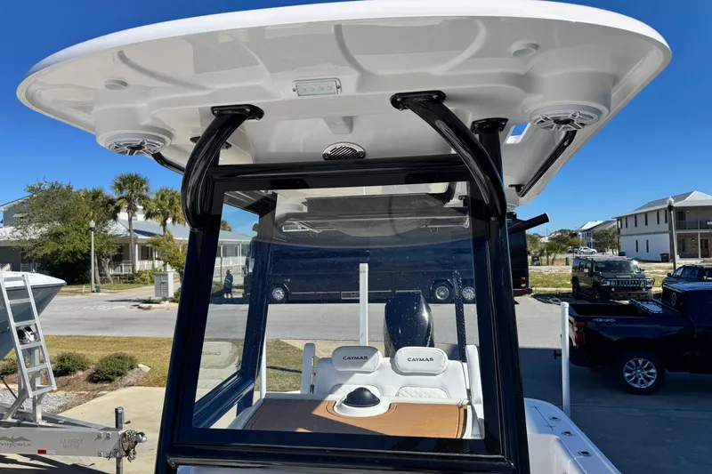 Slide: The Image of 2026 Caymas 28 HB boat with T-top and console, parked in a residential area. - 21