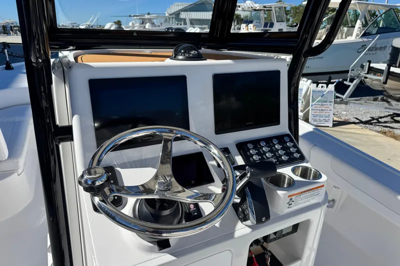 Slide: The Image of 2026 Caymas 28 HB boat dashboard with dual screens and steering wheel. - 23