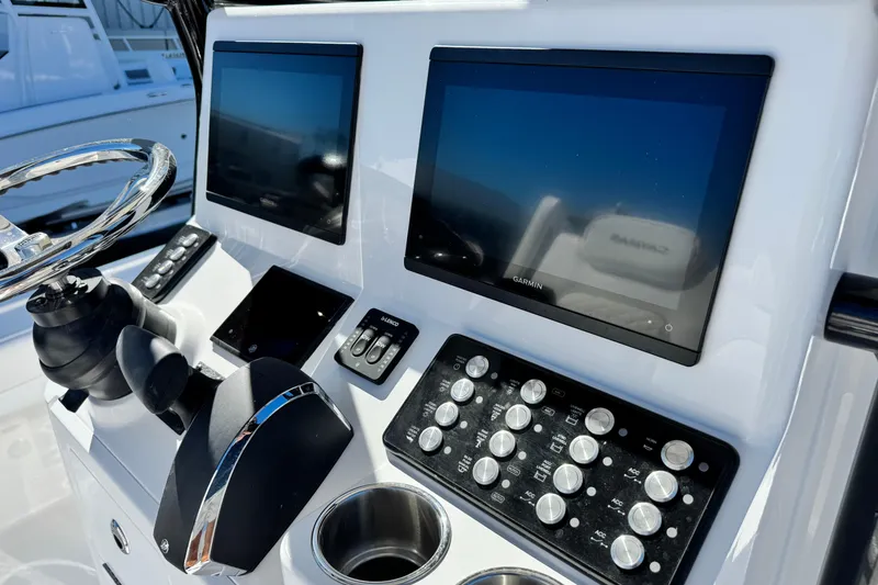 Slide: The Image of 2026 Caymas 28 HB boat dashboard with dual Garmin screens and control panel. - 26